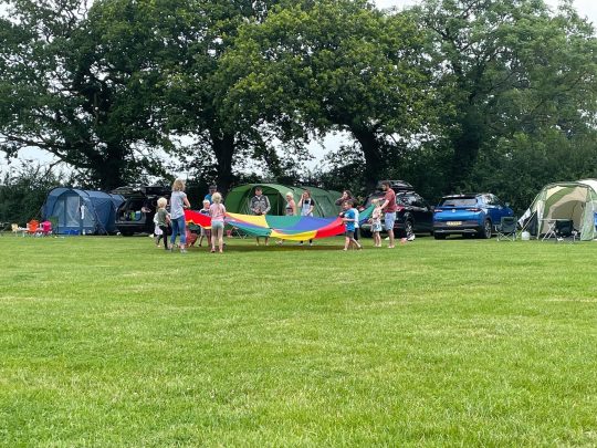 Pitch and Canvas | Glamping and Camping in Cheshire | People playing with parachute